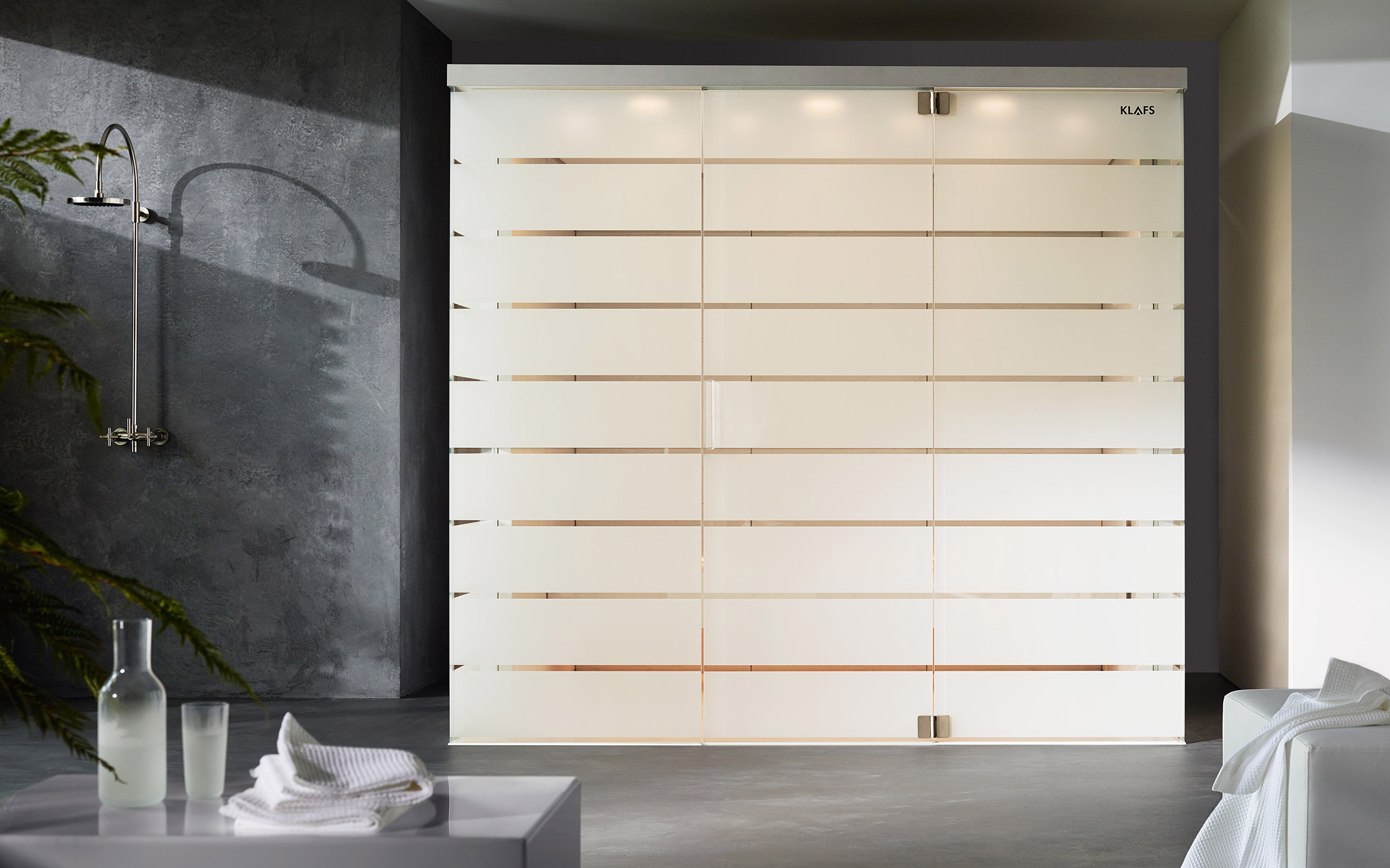 Turška savna Matteo Thun. Minimalističen izgled bele parne savne. Zasnoval jo je dizajner Matteo Thun. Na fotografiji je umeščena v sodobno kopalnico betonskega videza.