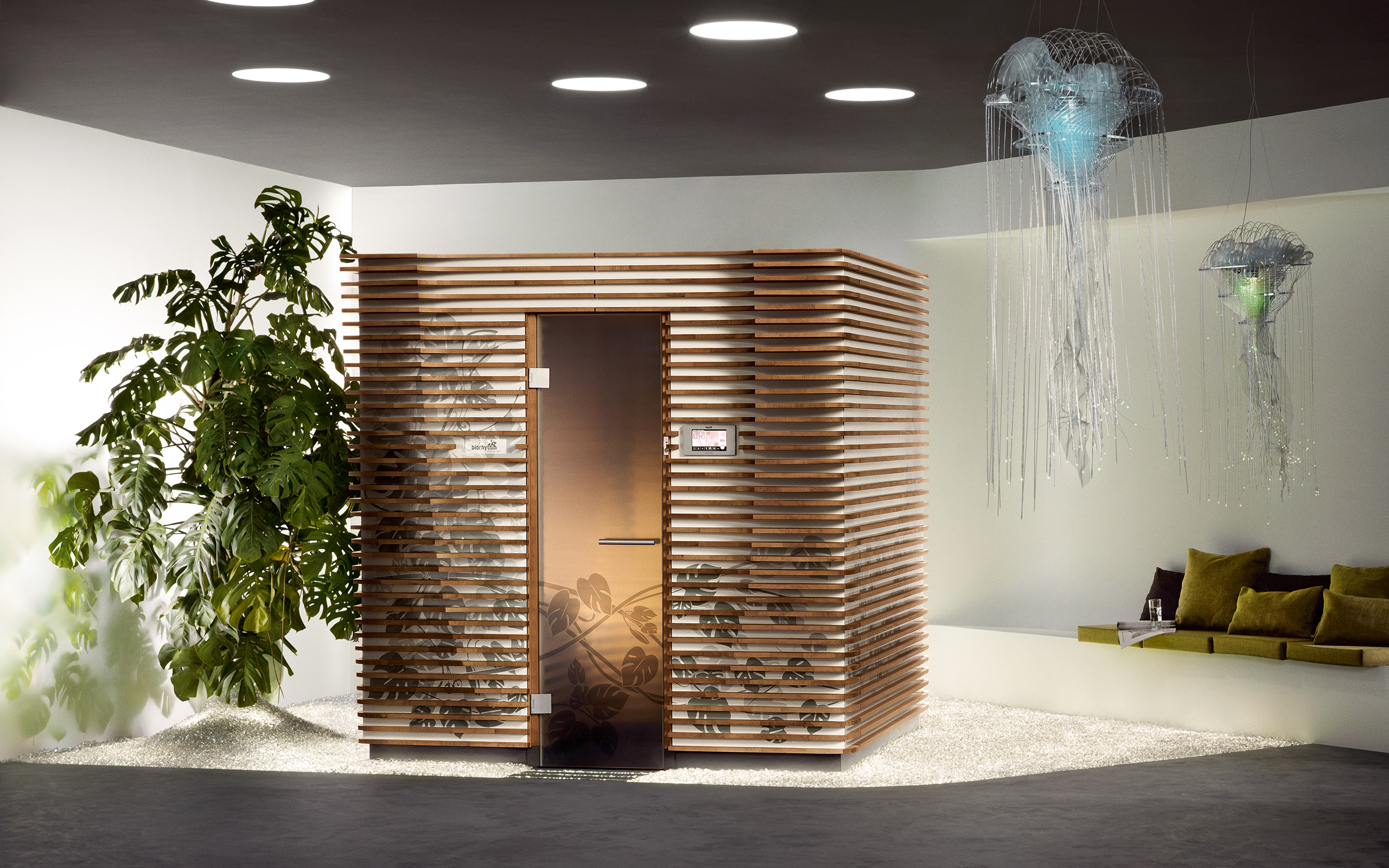 Finska Savna Biorhythm v dnevno bivalnem prostoru. Savna razgibanih linij, moderna osvetlitev dizajnerskih meduz in velika monstera. Sodoben izgled.