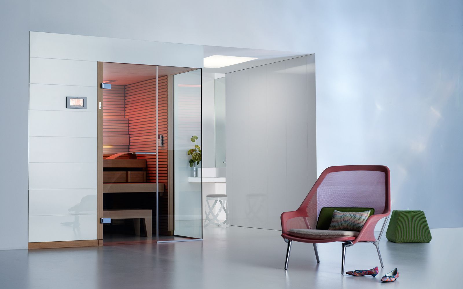 Preprosta finska savna čistega izgleda. Belo pročelje in eleganca. Svetel bel prostor z elementi rdeče in zelene barve.